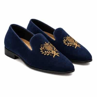 Dark blue Velvet Jalsa men's loafers with gold crest embroidery by Shoe Bespoke on a white background.
